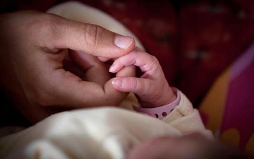 bebe et parent main dans la main
